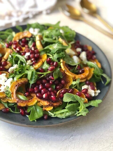 delicata squash with arugula and pomegranate seeds