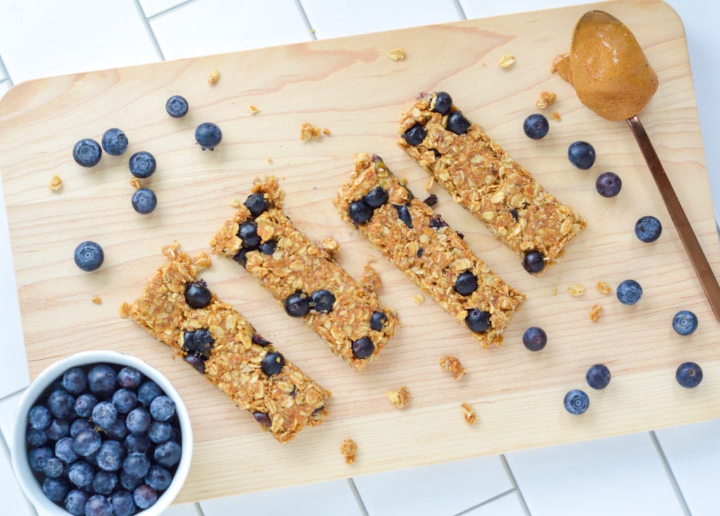 These No-Bake Blueberry Granola bars feature fresh blueberries and have very little added sugar. With just a few simple ingredients and no oven required, there are the perfect nutritious snack to whip up in the heat of the summer or anytime throughout the year! #nobake #granolabars #blueberrybars #healthysnack #healthygranolabar