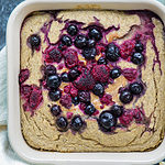 vegan baked oatmeal with berries on top in casserole dish