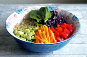 A vegan & gluten-free grain bowl topped with rainbow veggies