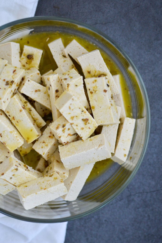 tofu in lemon marinade in glass bowl