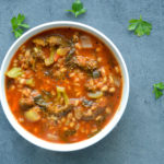 vegetable barley soup against black background